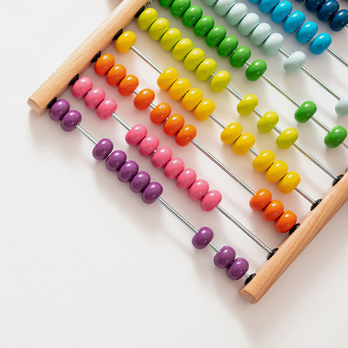 A wooden abacus with multicoloured beads, sitting on a white background.