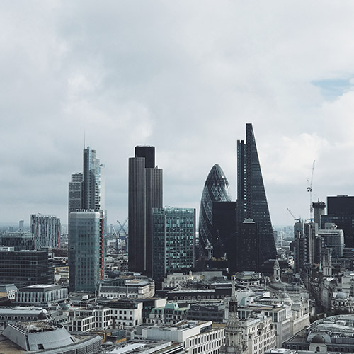 A skyline view of London, with a cloudy sky behind.