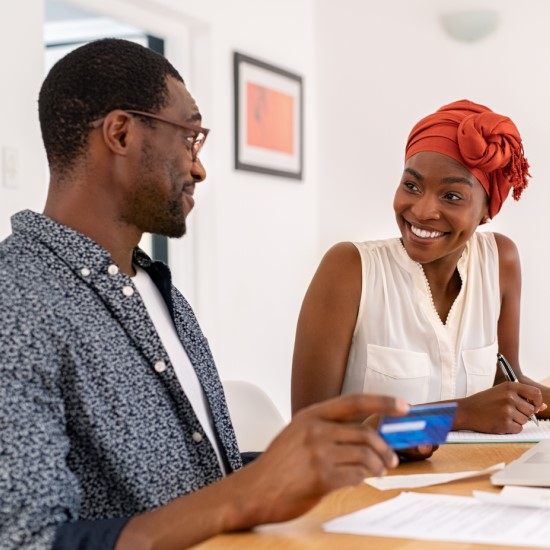 Smiling couple using a debit card at home
