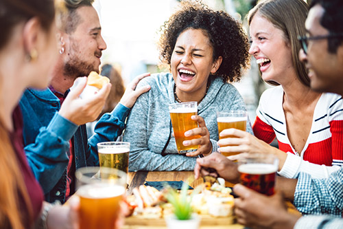 Group of friends laughing around a table