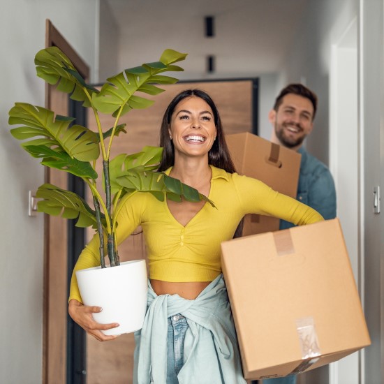 Man and woman carrying moving boxes